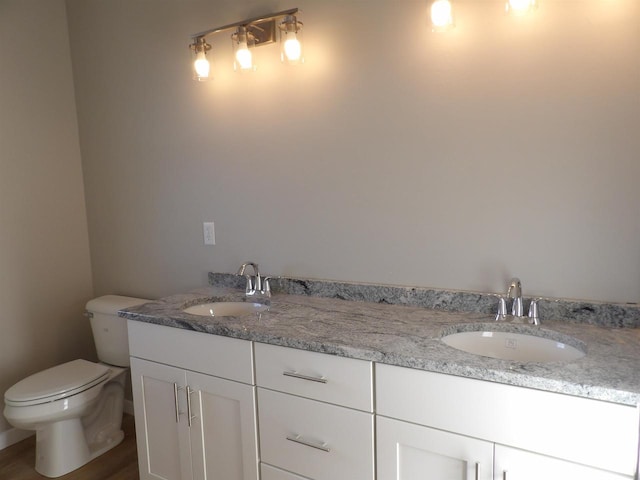 bathroom with hardwood / wood-style floors, vanity, and toilet