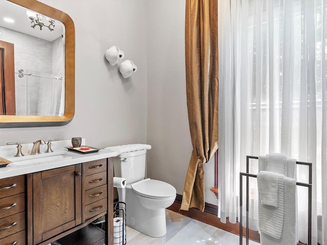 bathroom featuring tile patterned floors, vanity, toilet, and a shower with door