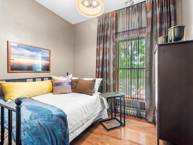 bedroom featuring hardwood / wood-style floors and lofted ceiling