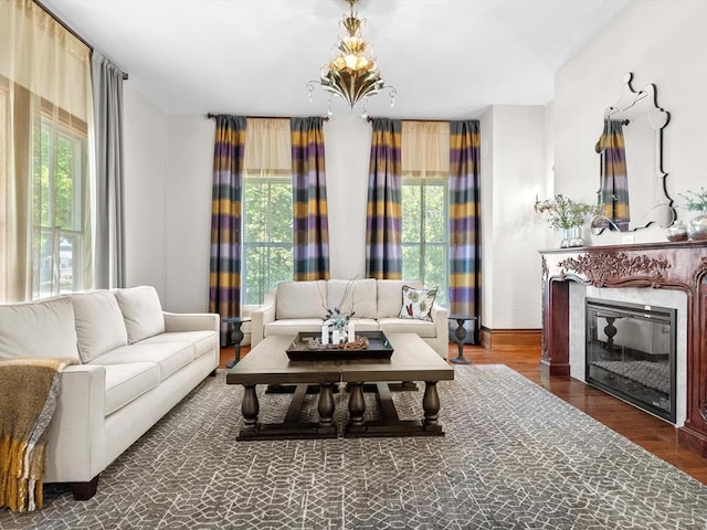 living room with a wealth of natural light, dark hardwood / wood-style floors, and an inviting chandelier