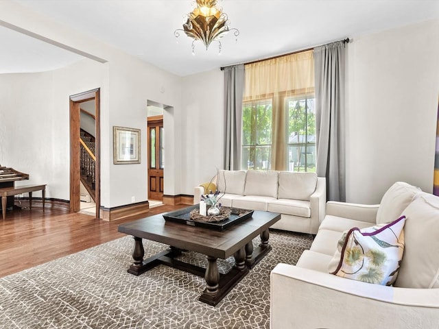 living room with wood-type flooring and an inviting chandelier