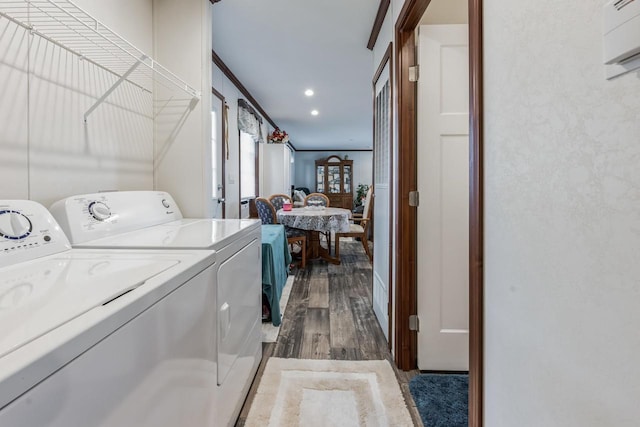 laundry room featuring dark hardwood / wood-style floors, washer and dryer, and crown molding