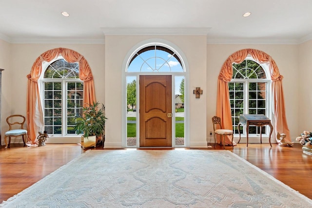 entrance foyer featuring wood-type flooring and crown molding