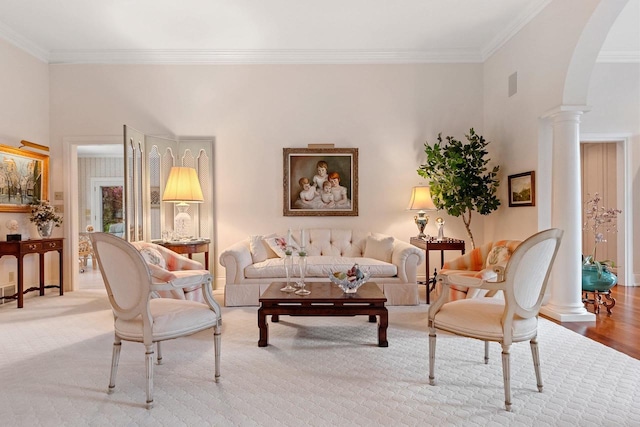 living room featuring ornate columns, crown molding, and wood-type flooring