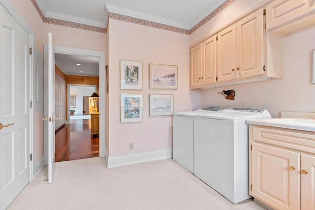 washroom featuring cabinets, light carpet, washing machine and dryer, and crown molding