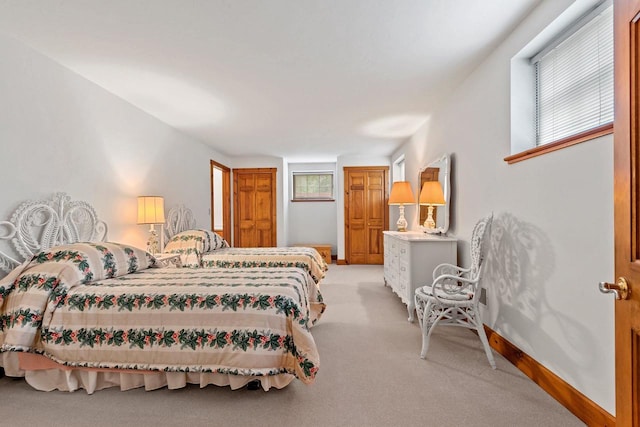 bedroom with light colored carpet and multiple windows