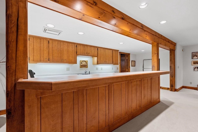 kitchen featuring kitchen peninsula, sink, light colored carpet, and white refrigerator