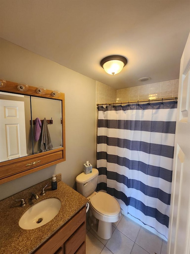 bathroom featuring tile patterned flooring, vanity, toilet, and walk in shower