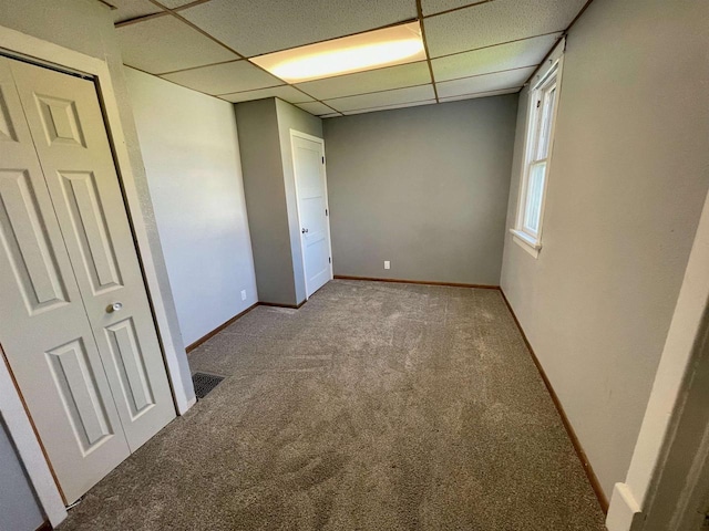 empty room featuring carpet flooring and a drop ceiling