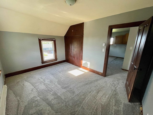 bonus room with a baseboard radiator, light colored carpet, and lofted ceiling