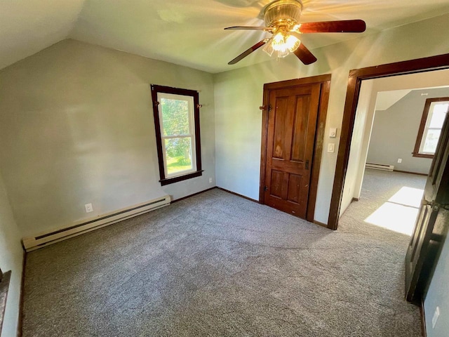 unfurnished bedroom featuring carpet flooring, vaulted ceiling, baseboard heating, and ceiling fan