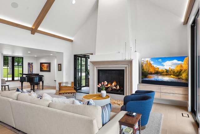 living room featuring beam ceiling, high vaulted ceiling, and light wood-type flooring