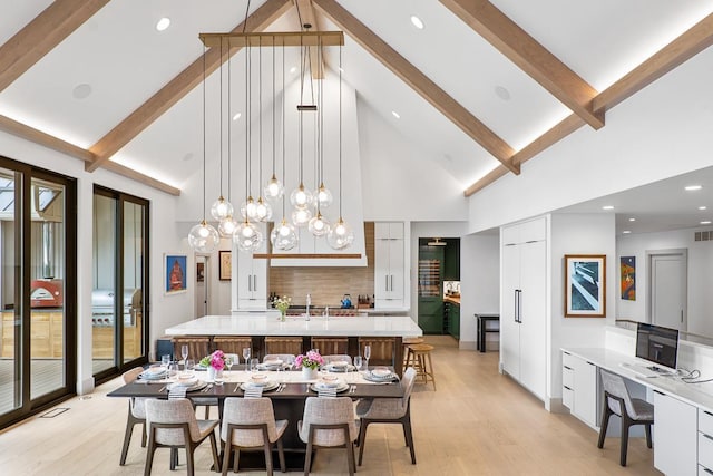 dining area with beamed ceiling, sink, high vaulted ceiling, and light hardwood / wood-style flooring