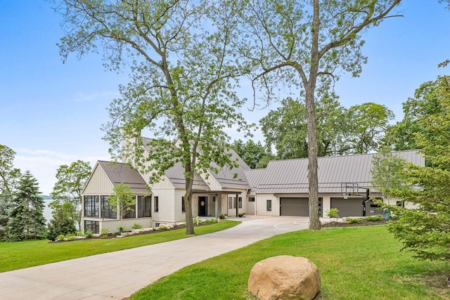 view of front of house with a garage, a front yard, and a sunroom