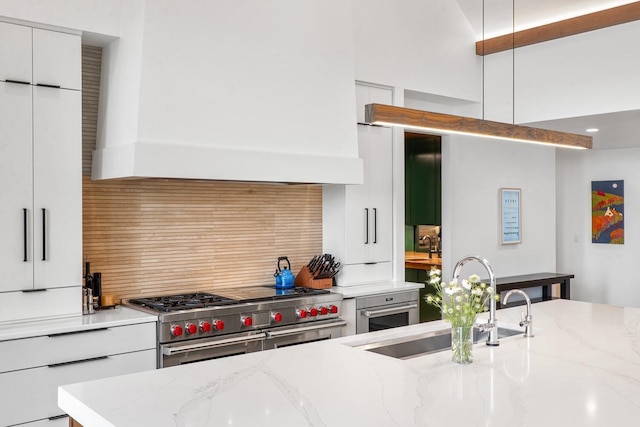 kitchen featuring custom exhaust hood, double oven range, sink, and light stone counters