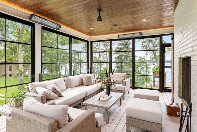 sunroom featuring a brick fireplace and wooden ceiling