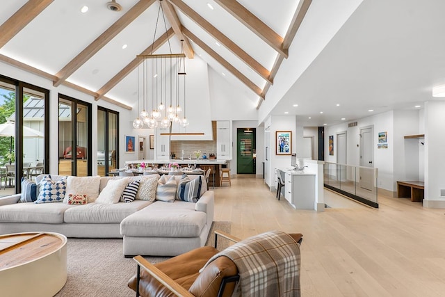 living room with high vaulted ceiling, beam ceiling, light hardwood / wood-style floors, and a notable chandelier