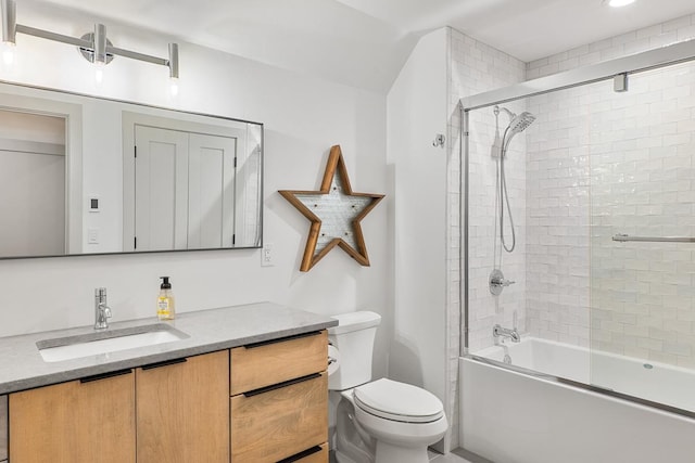 full bathroom featuring enclosed tub / shower combo, vanity, and toilet