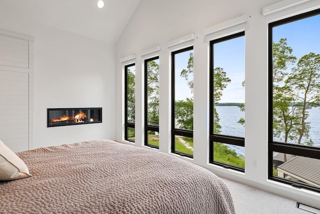 carpeted bedroom featuring lofted ceiling, multiple windows, and a water view