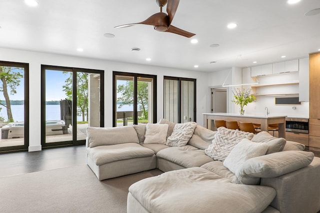 living room with a water view and ceiling fan