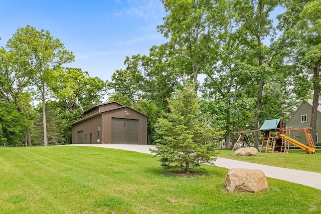 view of yard with a playground, a garage, and an outdoor structure