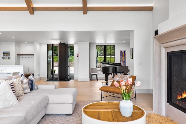 living room with beam ceiling and light hardwood / wood-style flooring