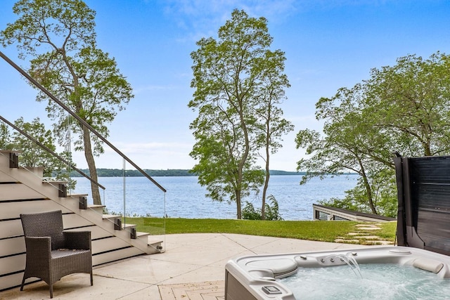 view of patio featuring a water view and a hot tub