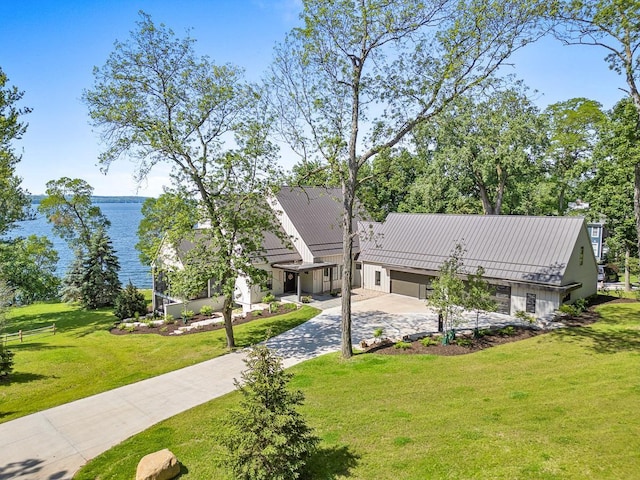 view of front facade with a garage, a water view, and a front yard