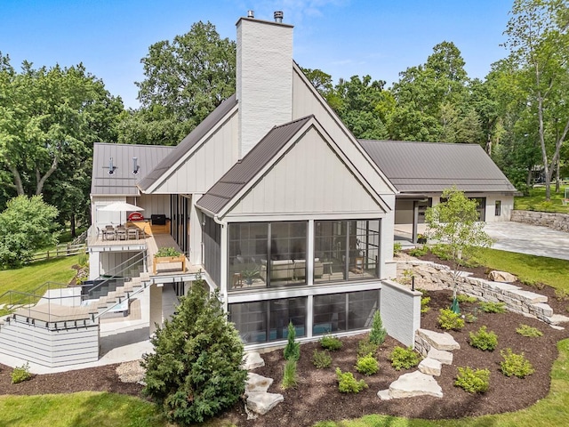 rear view of house featuring a sunroom