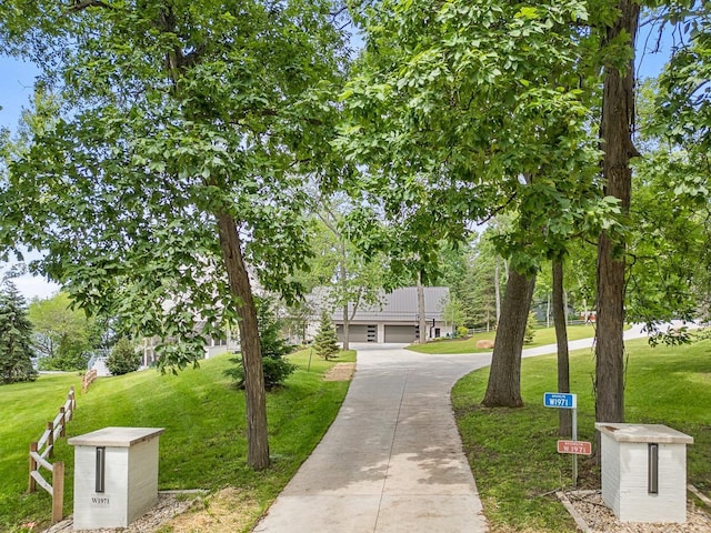 view of property's community featuring a garage and a lawn