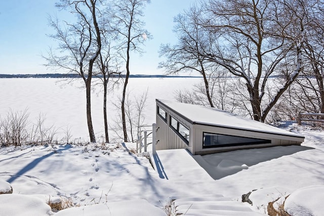 view of snowy exterior with a water view