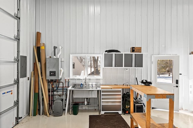 interior space featuring sink, a workshop area, water heater, concrete flooring, and electric panel