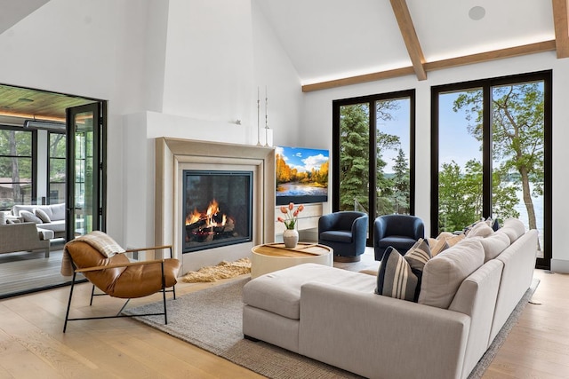 living room featuring beam ceiling, a high end fireplace, light hardwood / wood-style flooring, and high vaulted ceiling