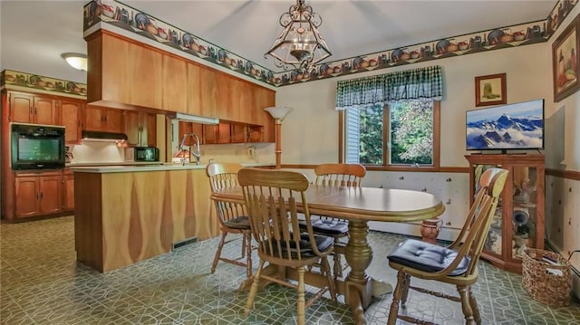 dining room featuring sink and a chandelier