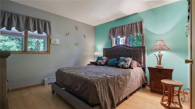 bedroom featuring a baseboard radiator and light hardwood / wood-style flooring