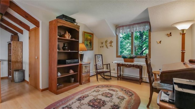 living area with a baseboard radiator, lofted ceiling, and hardwood / wood-style flooring