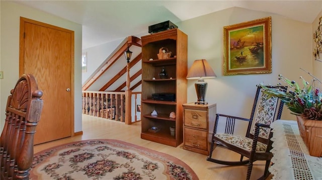 living area featuring lofted ceiling and light hardwood / wood-style flooring