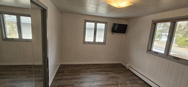 N9451 Parkway Rd, Crivitz, WI 54114 - unfurnished room featuring a baseboard heating unit, dark wood-style flooring, and wood walls
