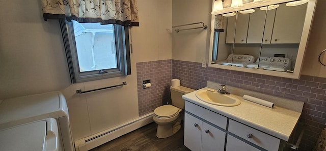 N9451 Parkway Rd, Crivitz, WI 54114 - half bath with a baseboard heating unit, washer and dryer, vanity, tile walls, and wainscoting