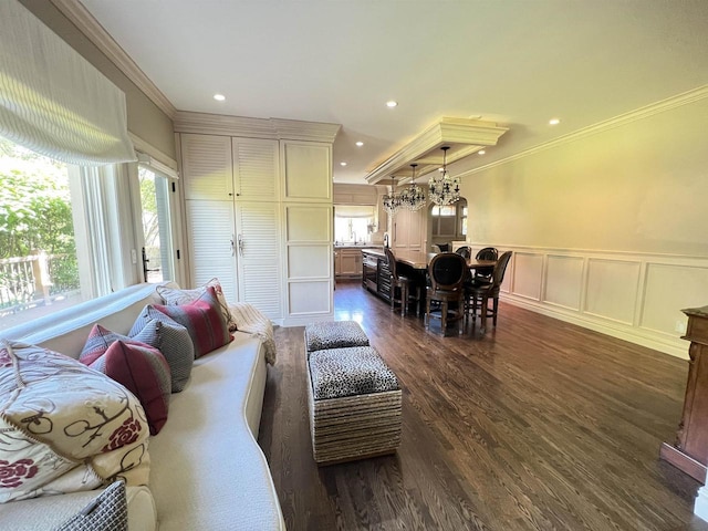 living room featuring dark hardwood / wood-style flooring, an inviting chandelier, and crown molding