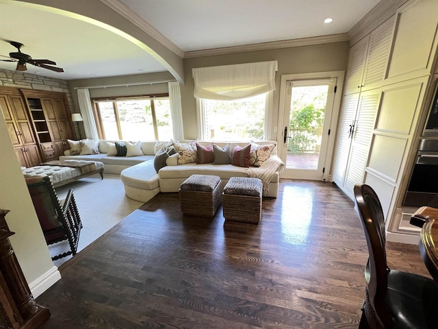 living room featuring dark hardwood / wood-style floors, ceiling fan, ornamental molding, and a wealth of natural light