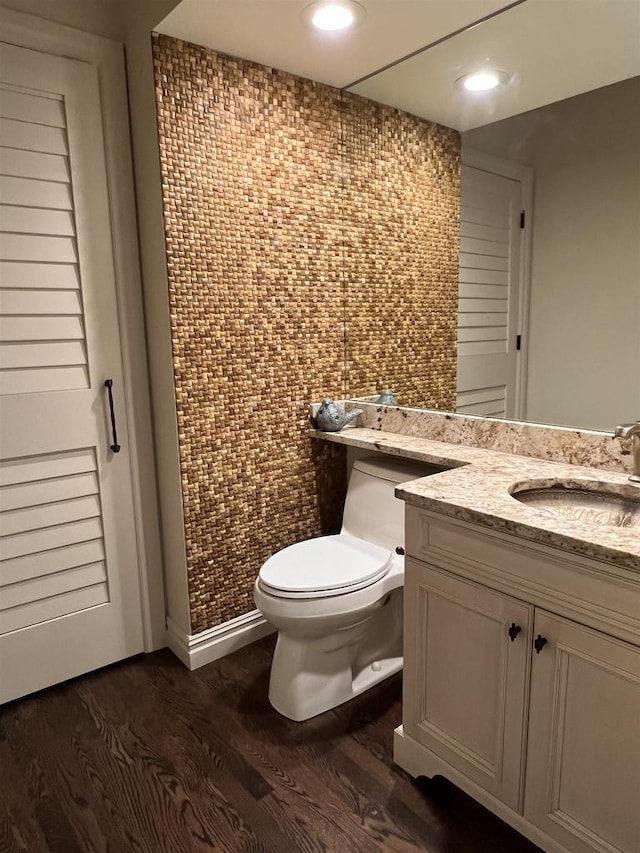 bathroom featuring vanity, wood-type flooring, tile walls, and toilet