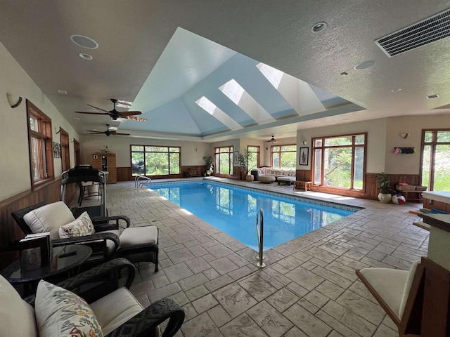 view of swimming pool with a skylight and ceiling fan