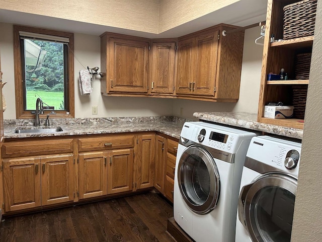 laundry area featuring cabinets, dark hardwood / wood-style flooring, sink, and washing machine and clothes dryer