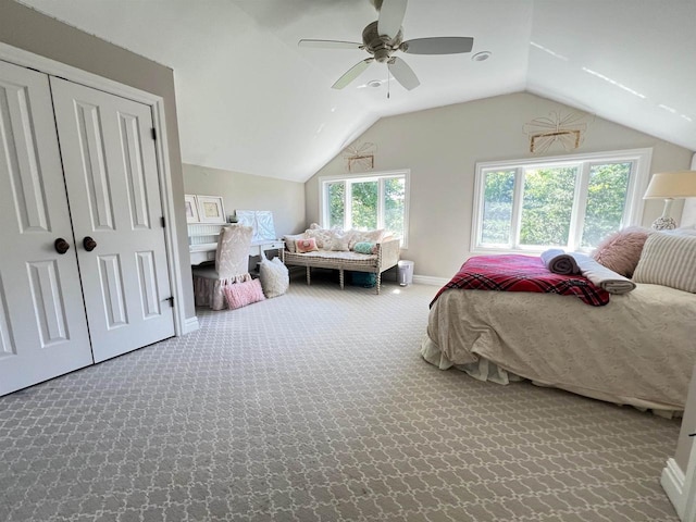 carpeted bedroom with ceiling fan, a closet, and vaulted ceiling