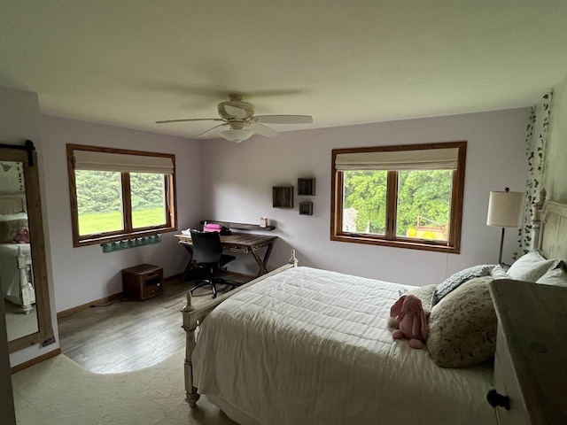 bedroom with multiple windows, ceiling fan, and light hardwood / wood-style flooring