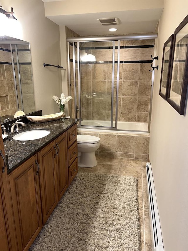 full bathroom featuring vanity, tile patterned floors, combined bath / shower with glass door, toilet, and baseboard heating