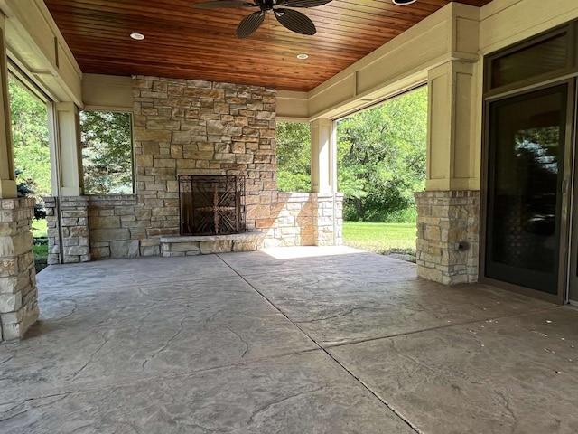 view of patio / terrace featuring an outdoor stone fireplace and ceiling fan