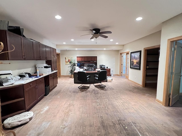 kitchen featuring a kitchen breakfast bar, dark brown cabinetry, light hardwood / wood-style floors, and ceiling fan