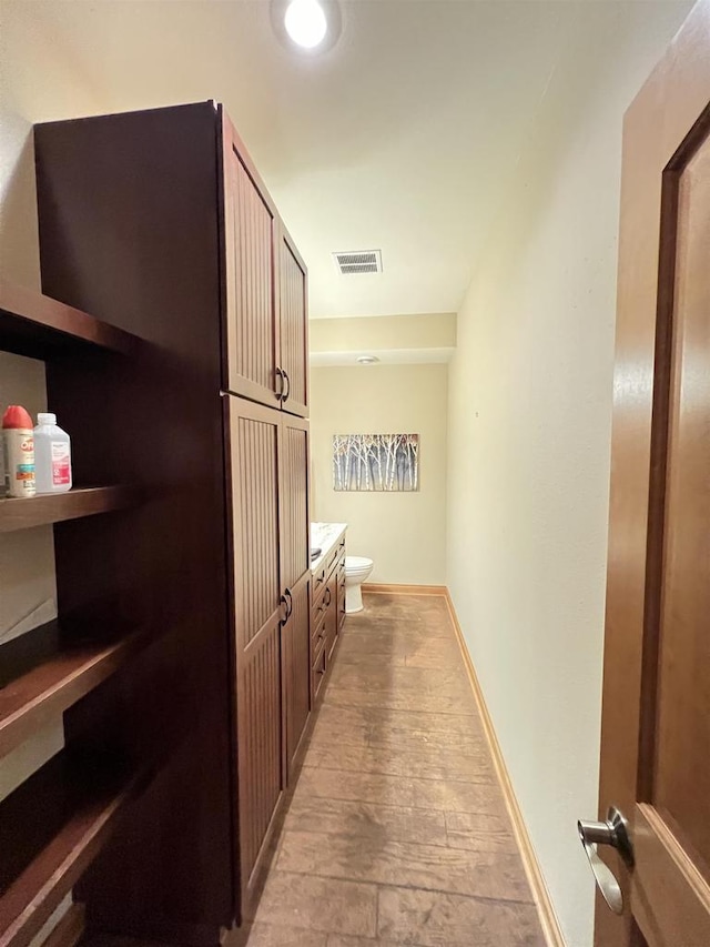 interior space featuring vanity, hardwood / wood-style flooring, and toilet